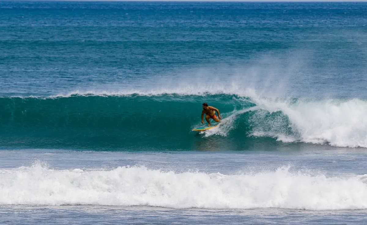 Surfer executing a bottom turn on a clean right wave.