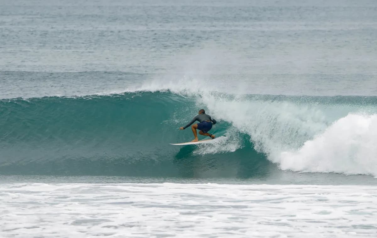 Surfer skillfully rides a peeling wave at Playa Colorado.