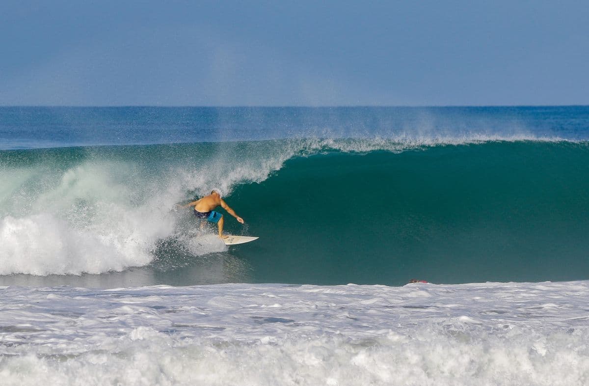 Surfer rides inside a perfect turquoise barrel.