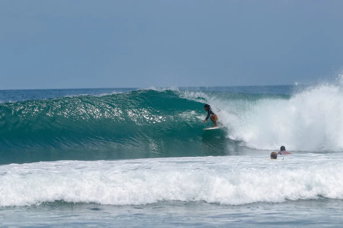 Surfer jeynner-granado rides a right-breaking wave with style.