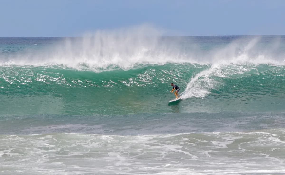 Surfer rides a powerful green wave at Panga Drops.
