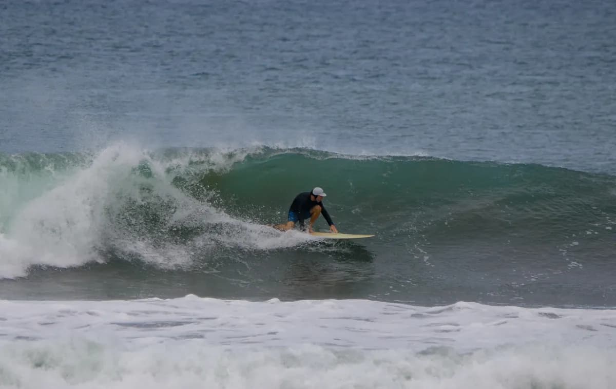 Surfer skillfully rides inside a green wave barrel.