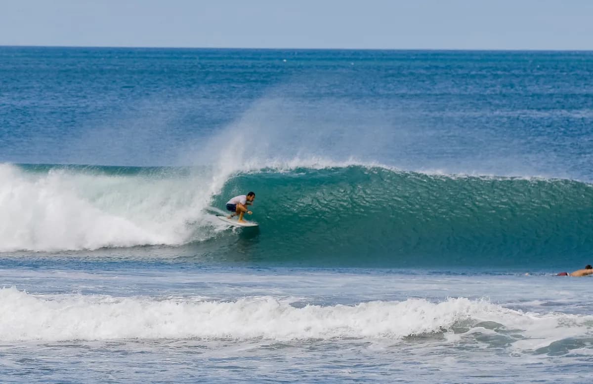 Surfer skillfully rides inside a perfect green barrel.