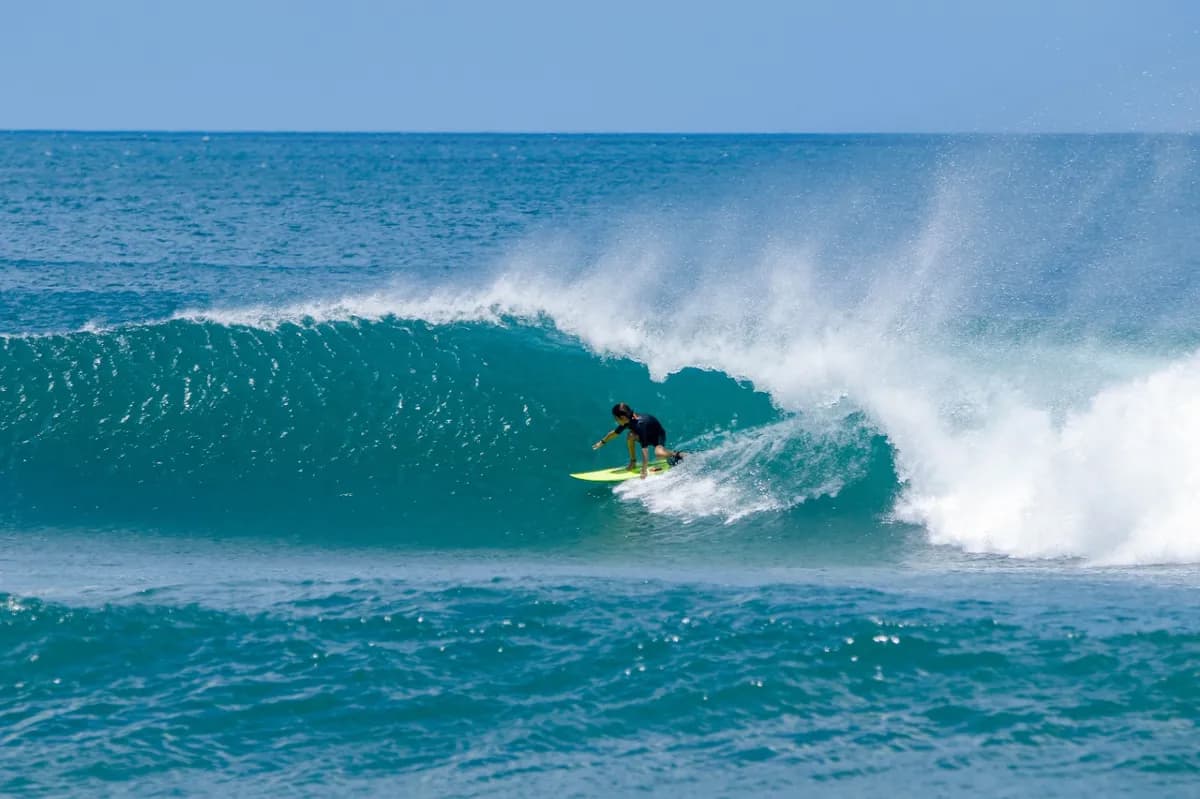 Surfer rides a peeling wave on a clear day.