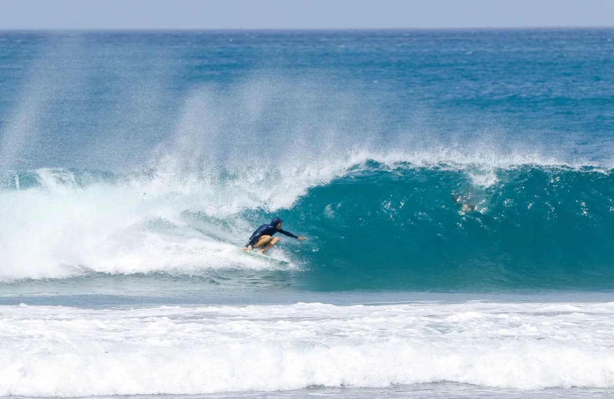 Surfer dropping into a blue wave at Playa Colorado.