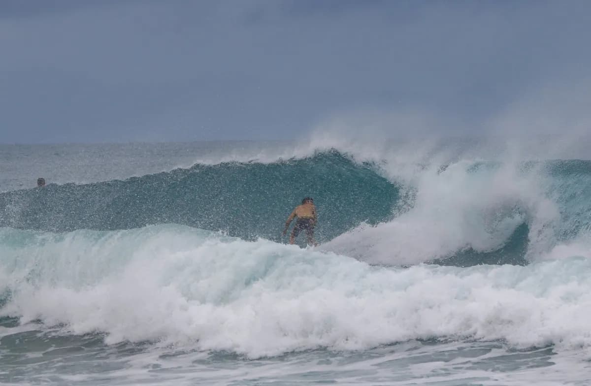 Surfer charges through a clear blue barrel at Playa Colorado.