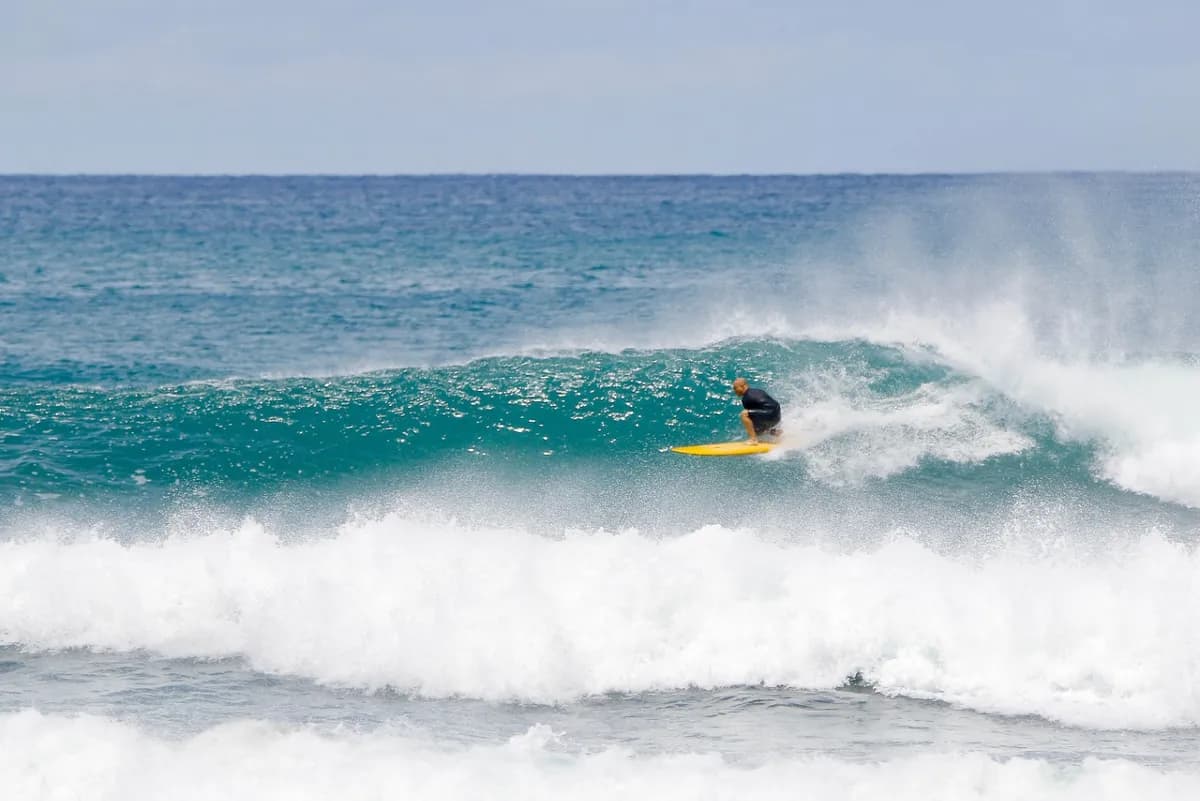 Surfer rides a clean wave with precision at Panga Drops.