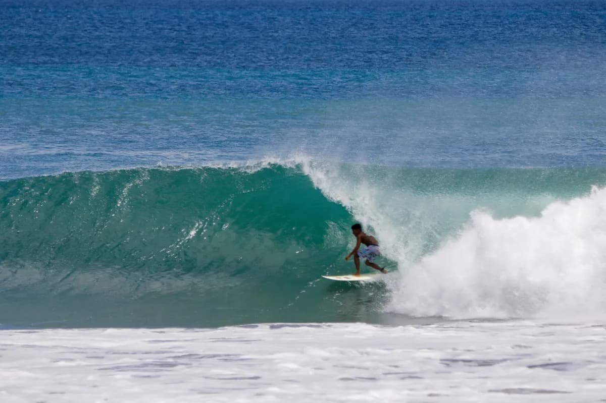 Surfer rides inside a glassy, green barrel.