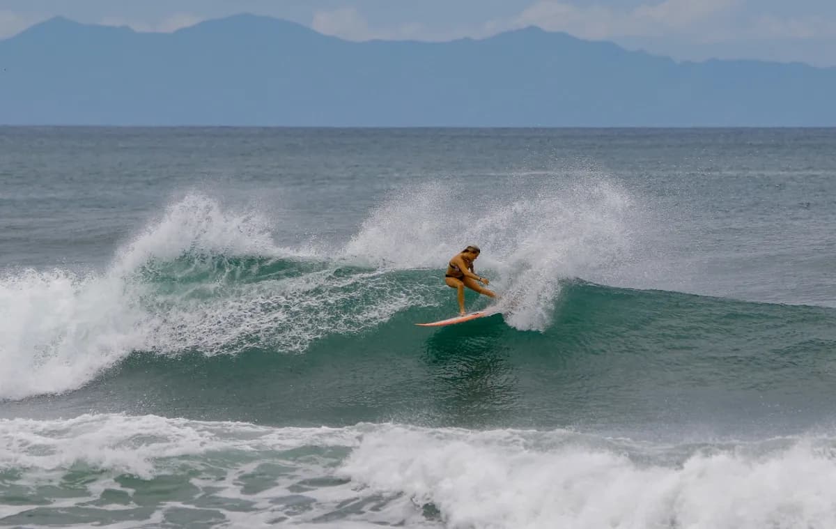 Surfer skillfully carves down a powerful wave.