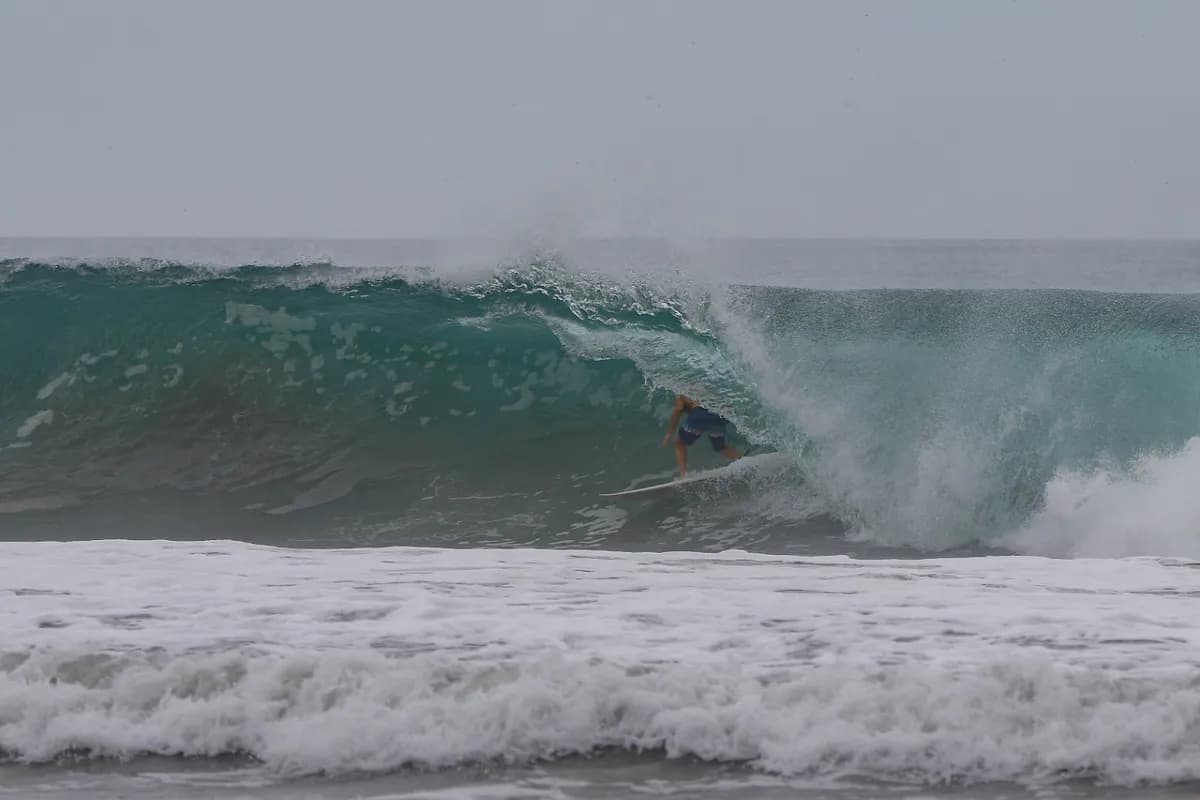 Surfer rides deep inside a powerful barrel wave.
