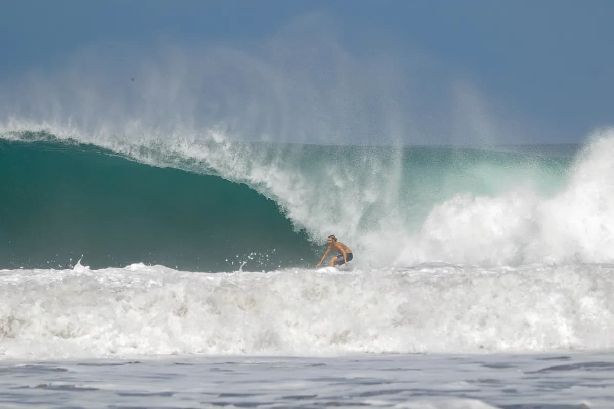 Surfer powers through a perfect overhead barrel.