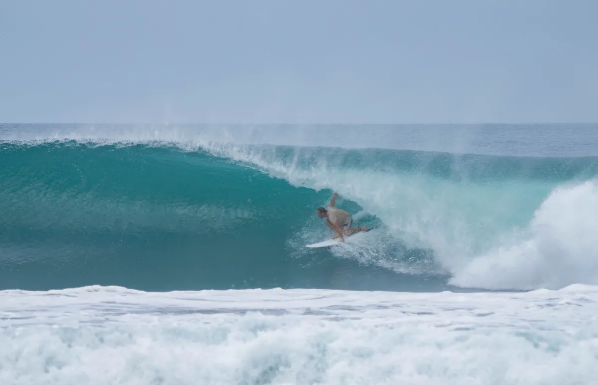 Surfer tucks into a perfect right-hand barrel.