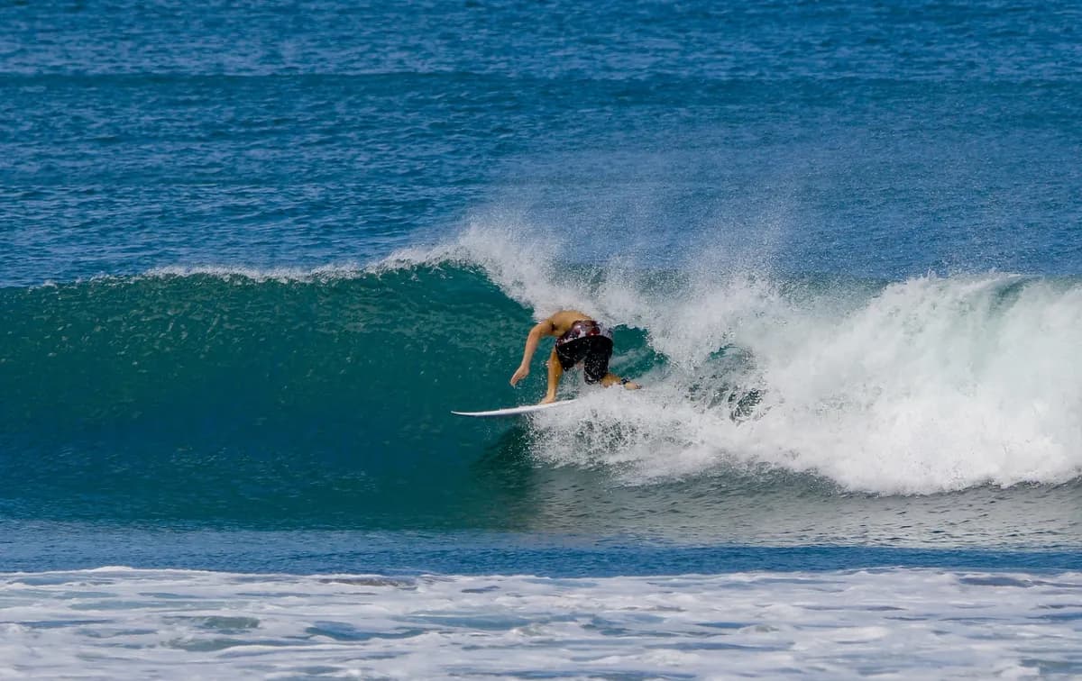 Surfer rides a perfect barrel, tightly tucked inside.