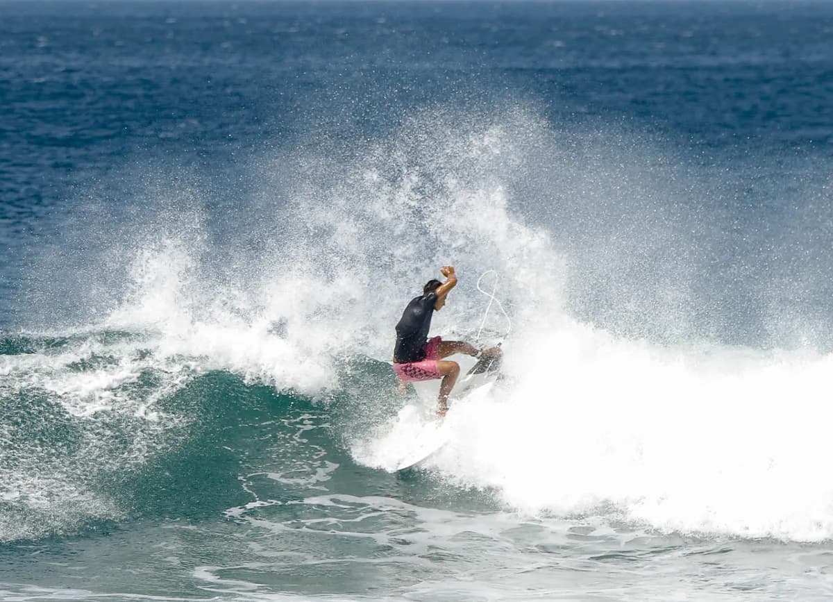 Surfer launches off wave in a raw display of energy.