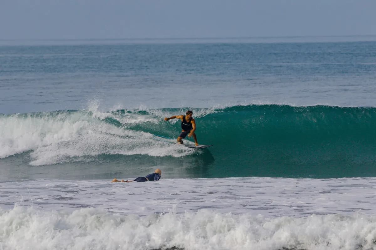 Surfer rides a glassy wave with smooth style.