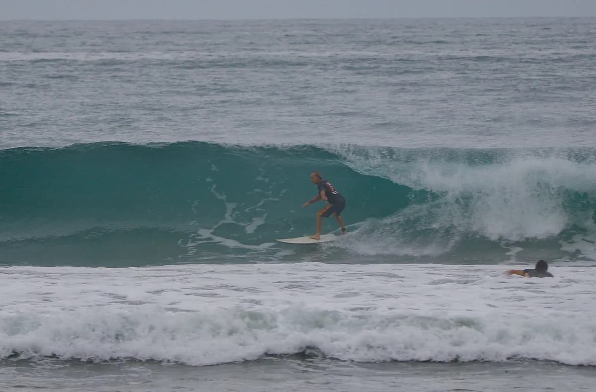 Surfer rides a clean wave with smooth style.
