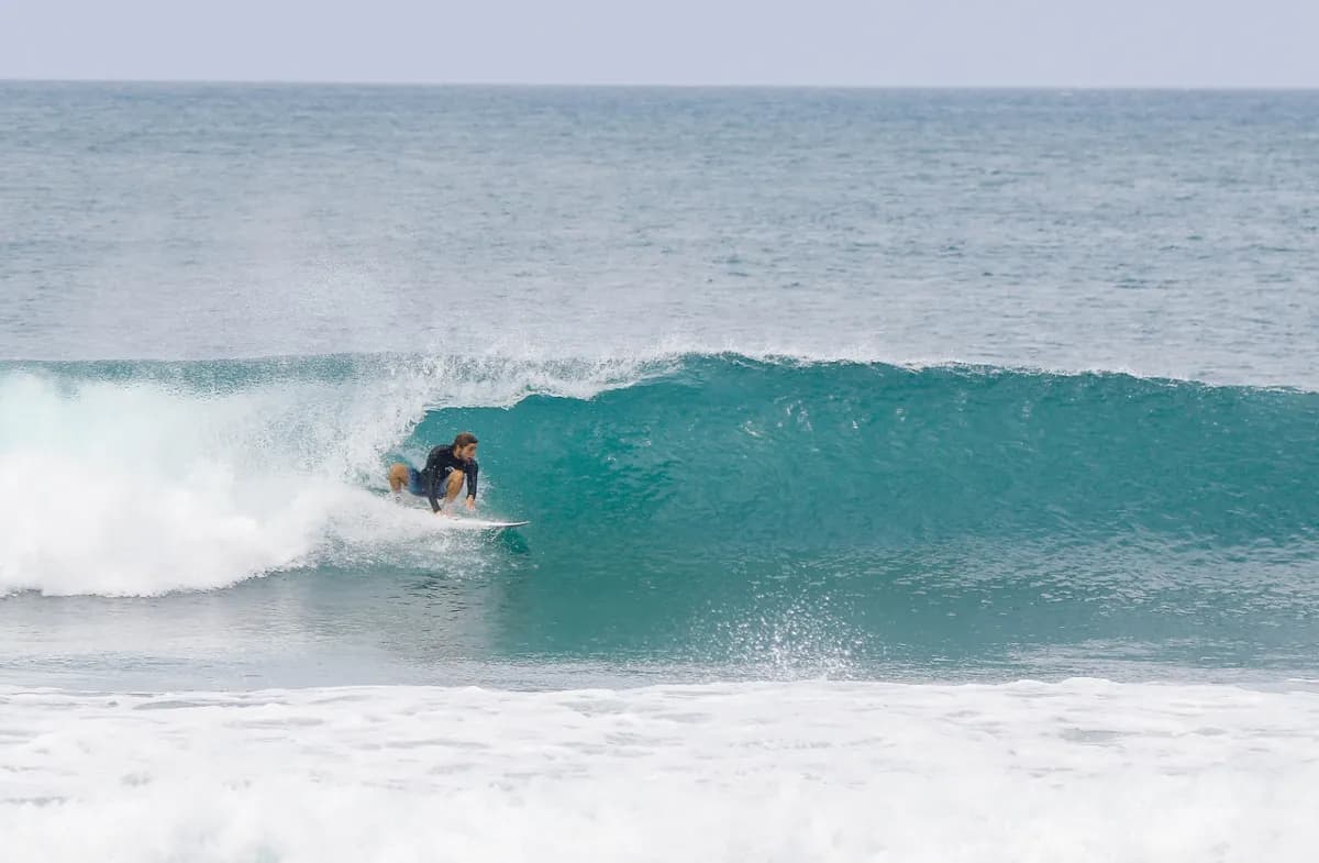 Surfer rides inside a perfect, turquoise barrel.