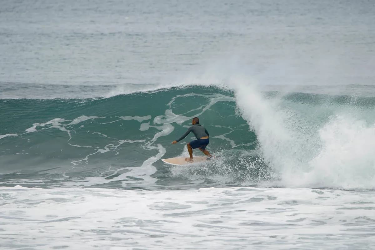 Surfer rides along an open wave face.