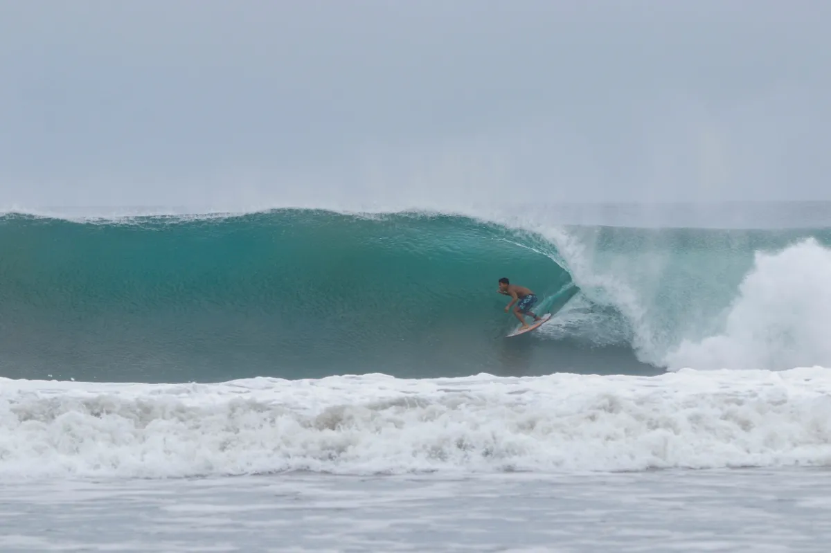 Surfer tucks into a clean overhead barrel at Playa Colorado.