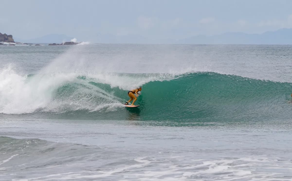 Surfer skillfully rides inside a perfect green barrel.