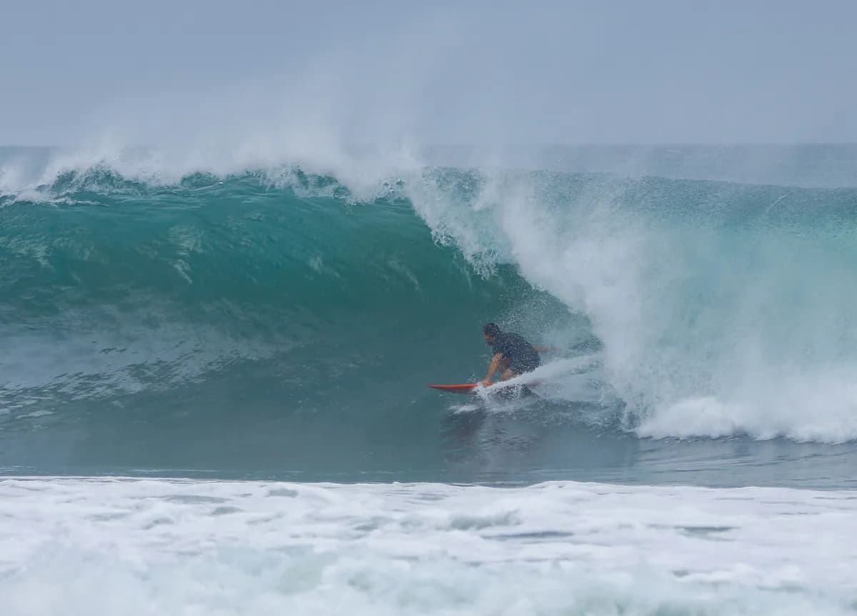Surfer rides inside a hollow barrel with precision.