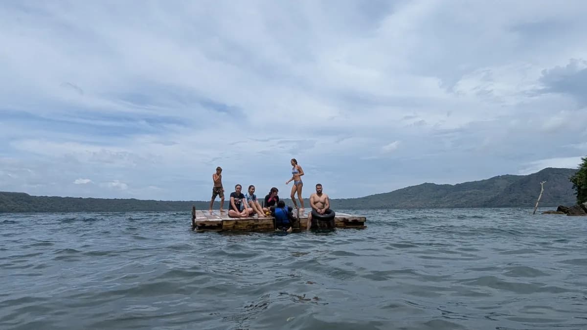 Group relaxing on a floating platform in calm waters.