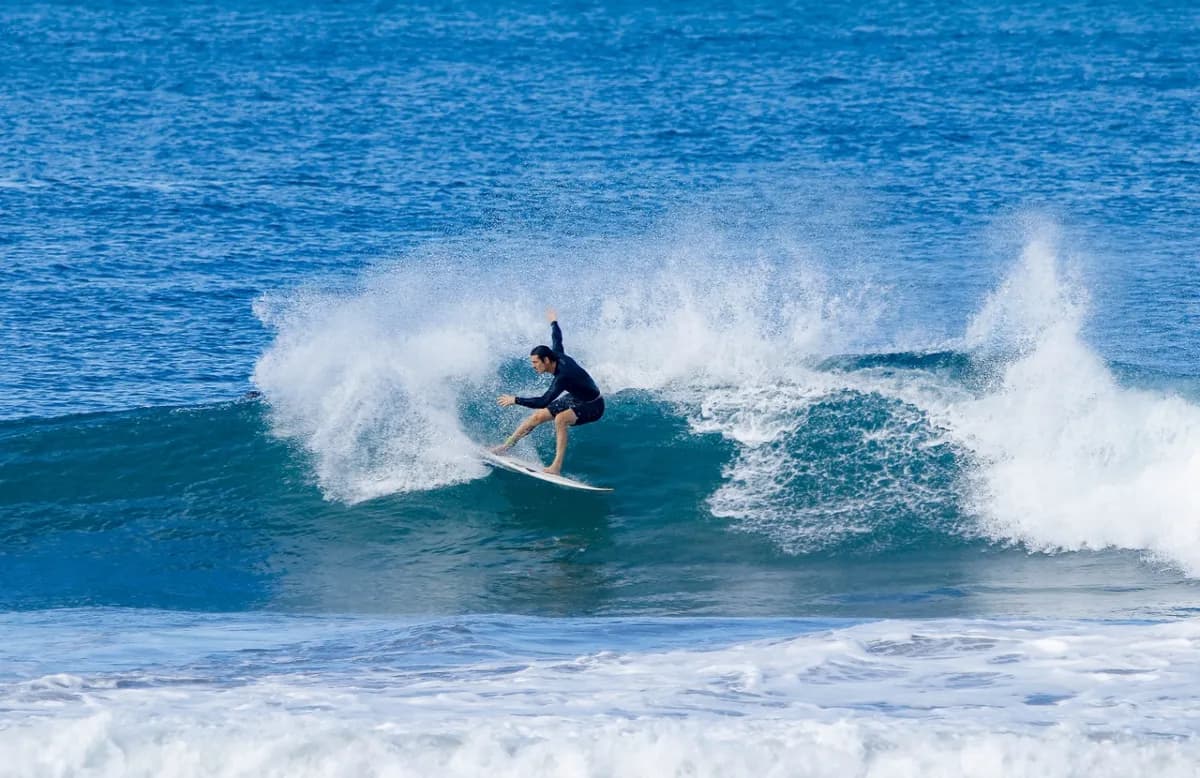 Surfer executing a powerful cutback on a blue wave.