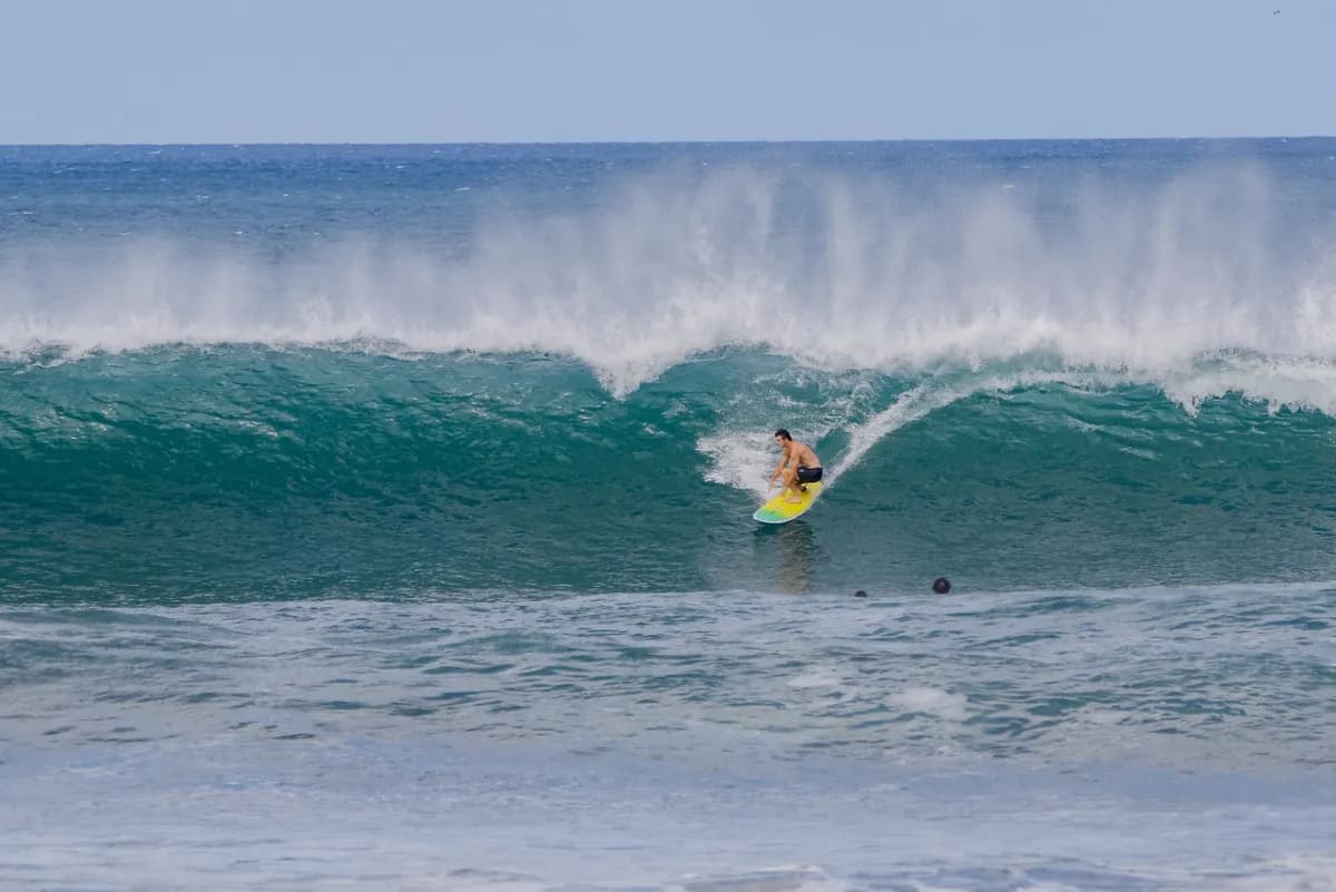 Surfer rides a powerful wave in the ocean.