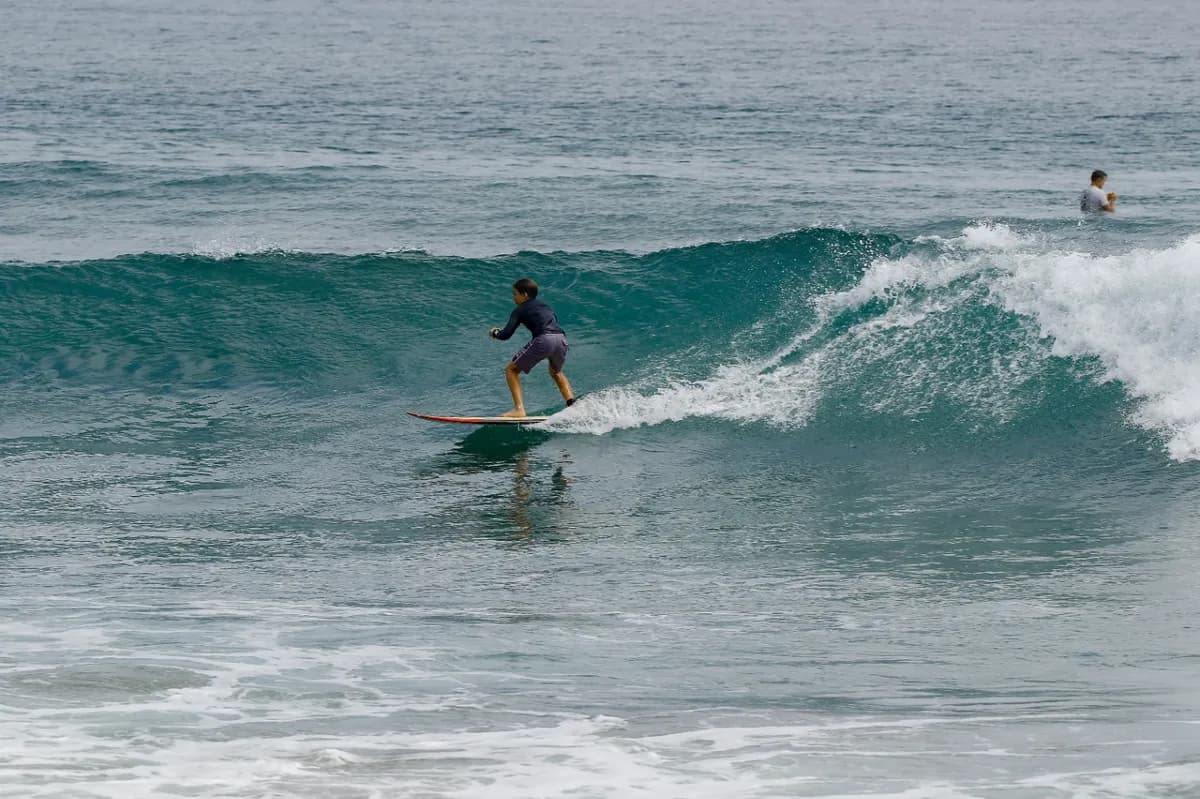 Surfer riding a clean, right-breaking wave with style.