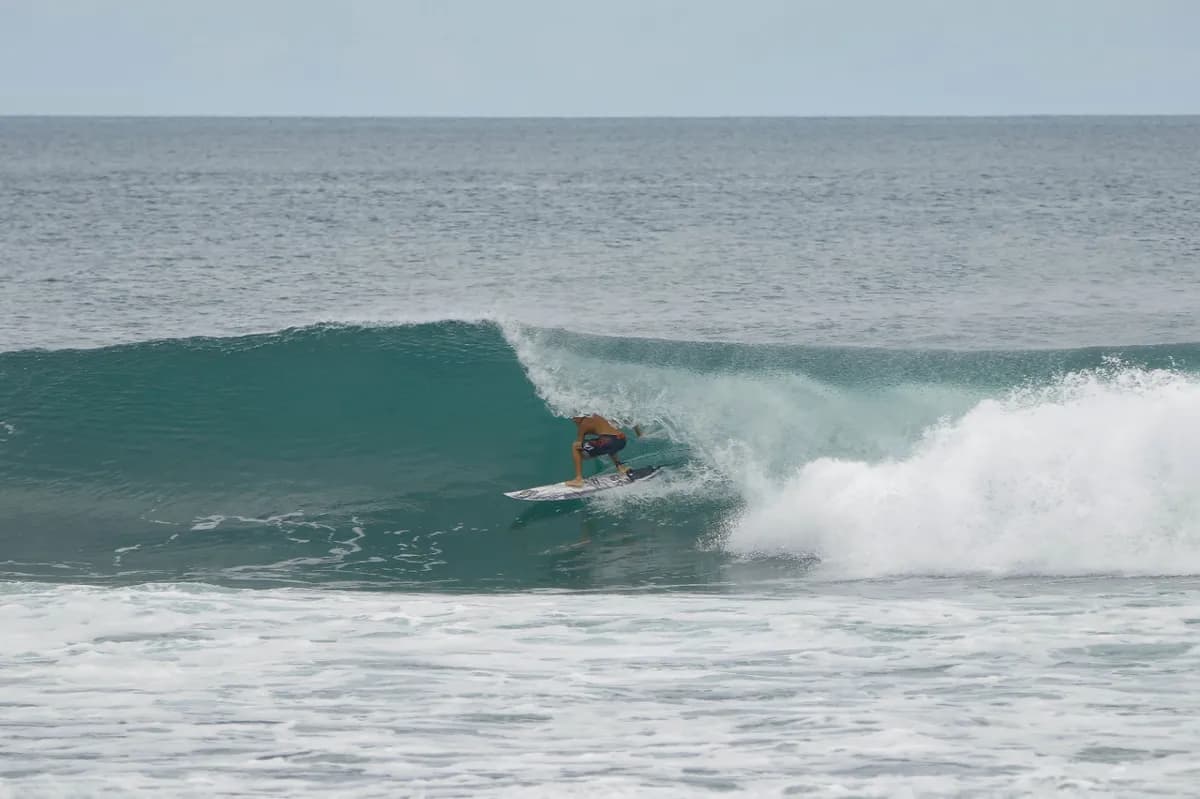 Surfer rides inside a hollow wave on a right.