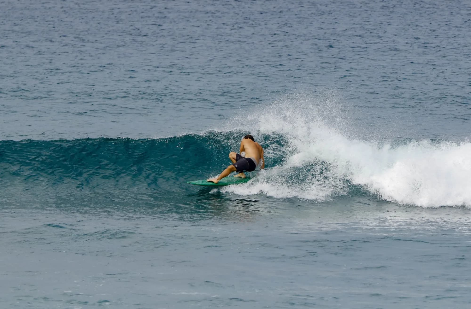 Surfer gracefully executes a smooth cutback on a clear wave.