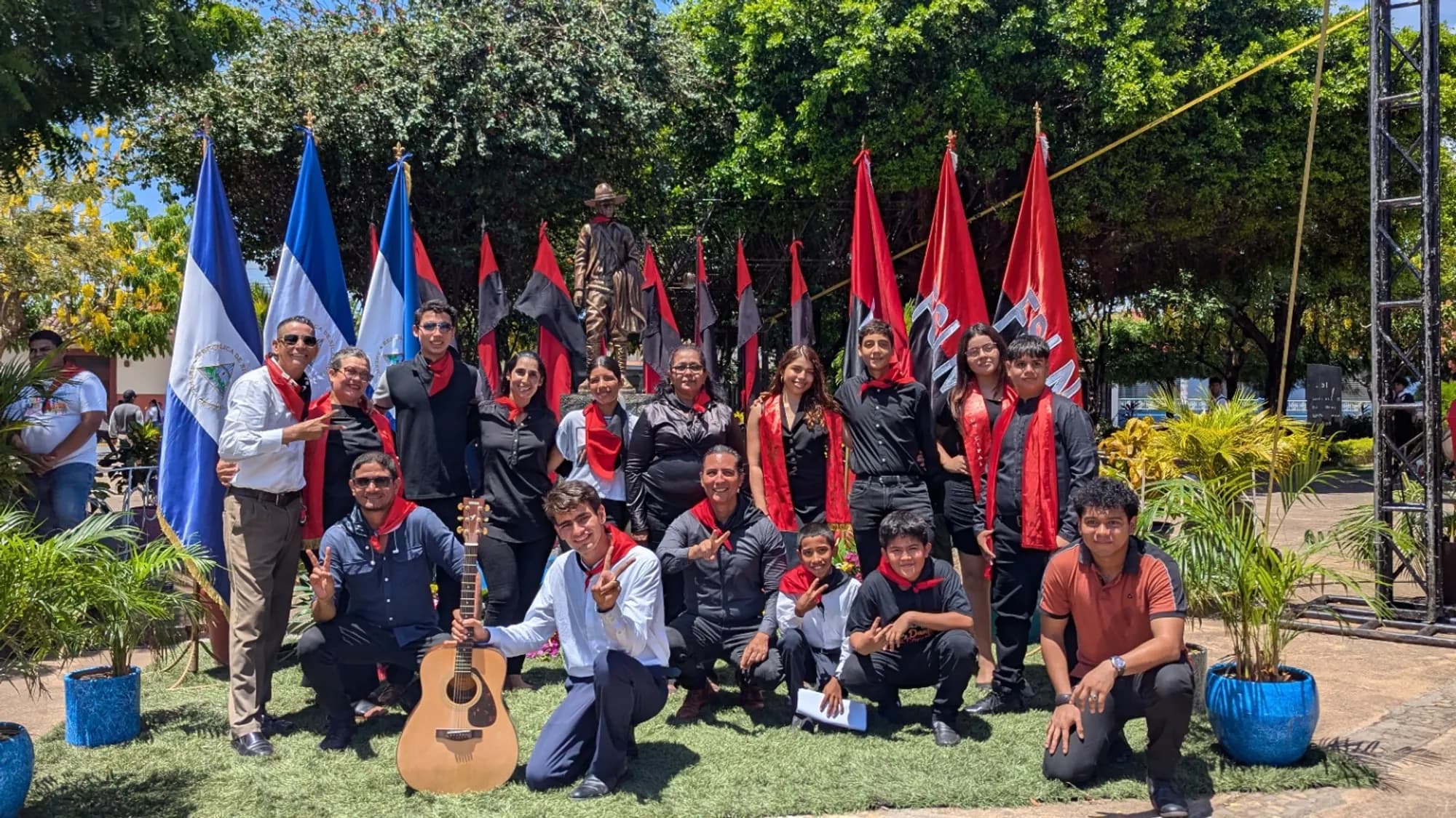 Group standing with flags in a park setting.