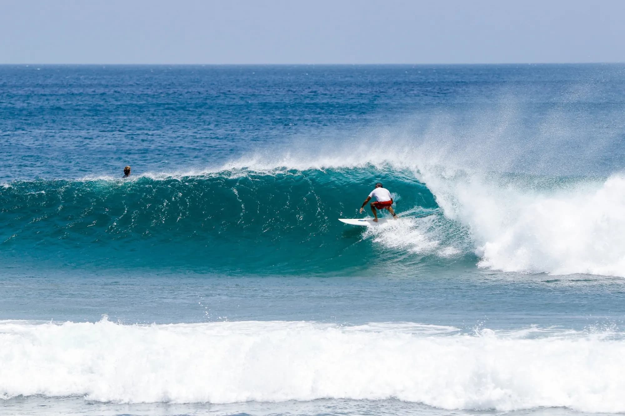 Surfer expertly riding a perfect right-hand barrel.