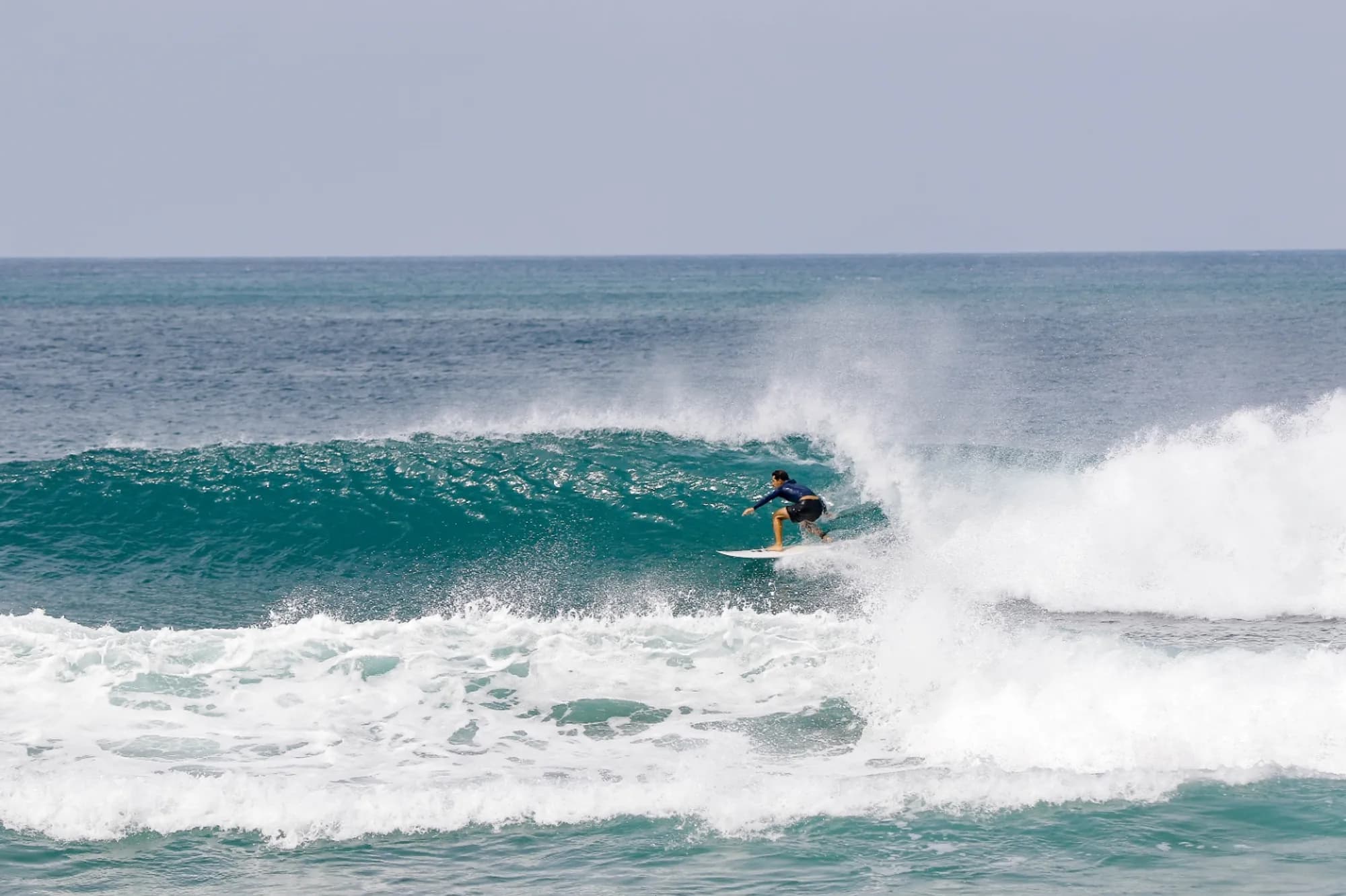 Surfer riding a clean wave with a powerful stance.