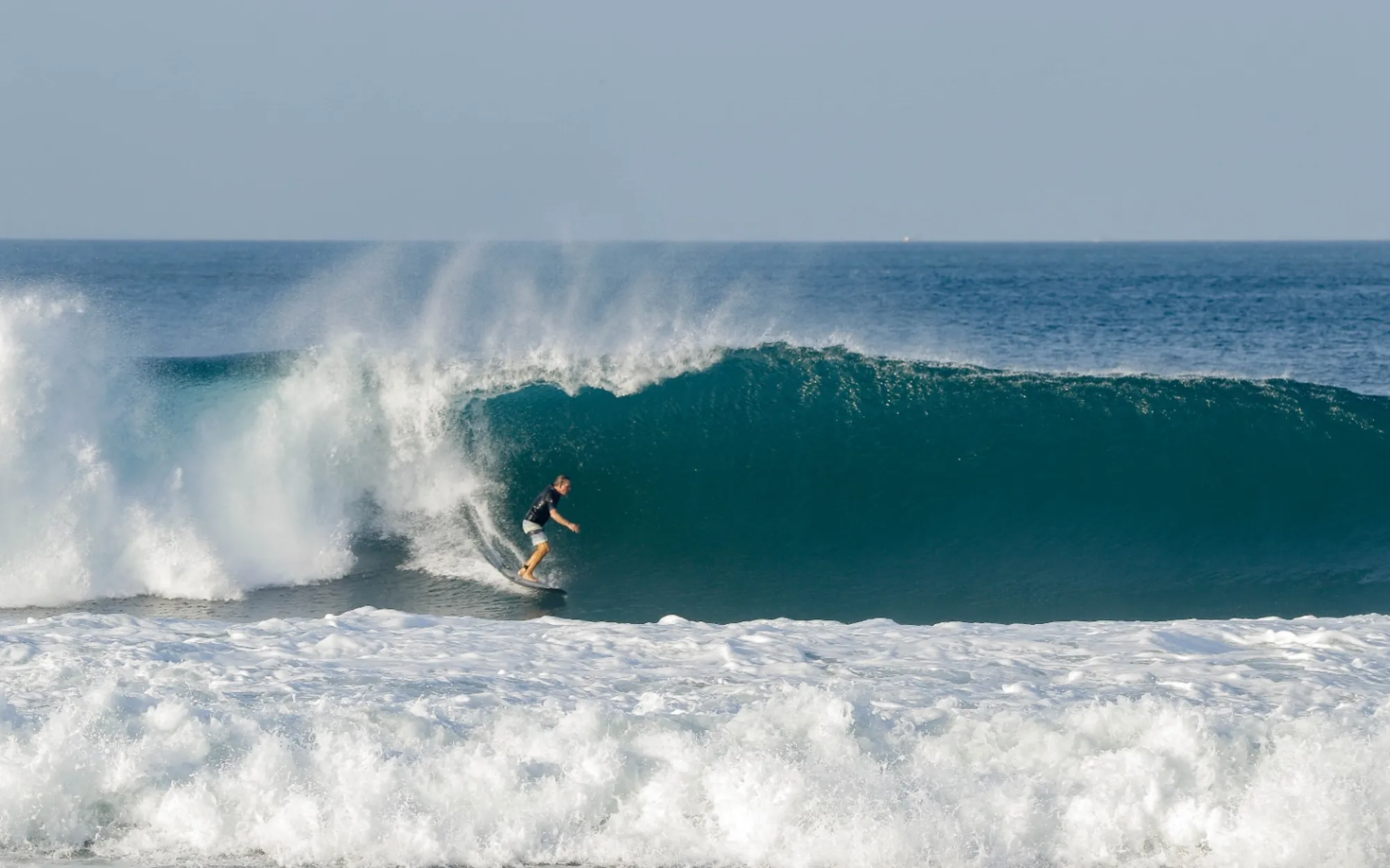 Surfer rides a perfect barrel with skill and style.