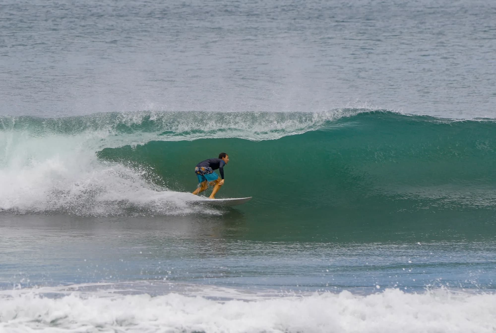 Surfer riding a perfect green barrel wave.
