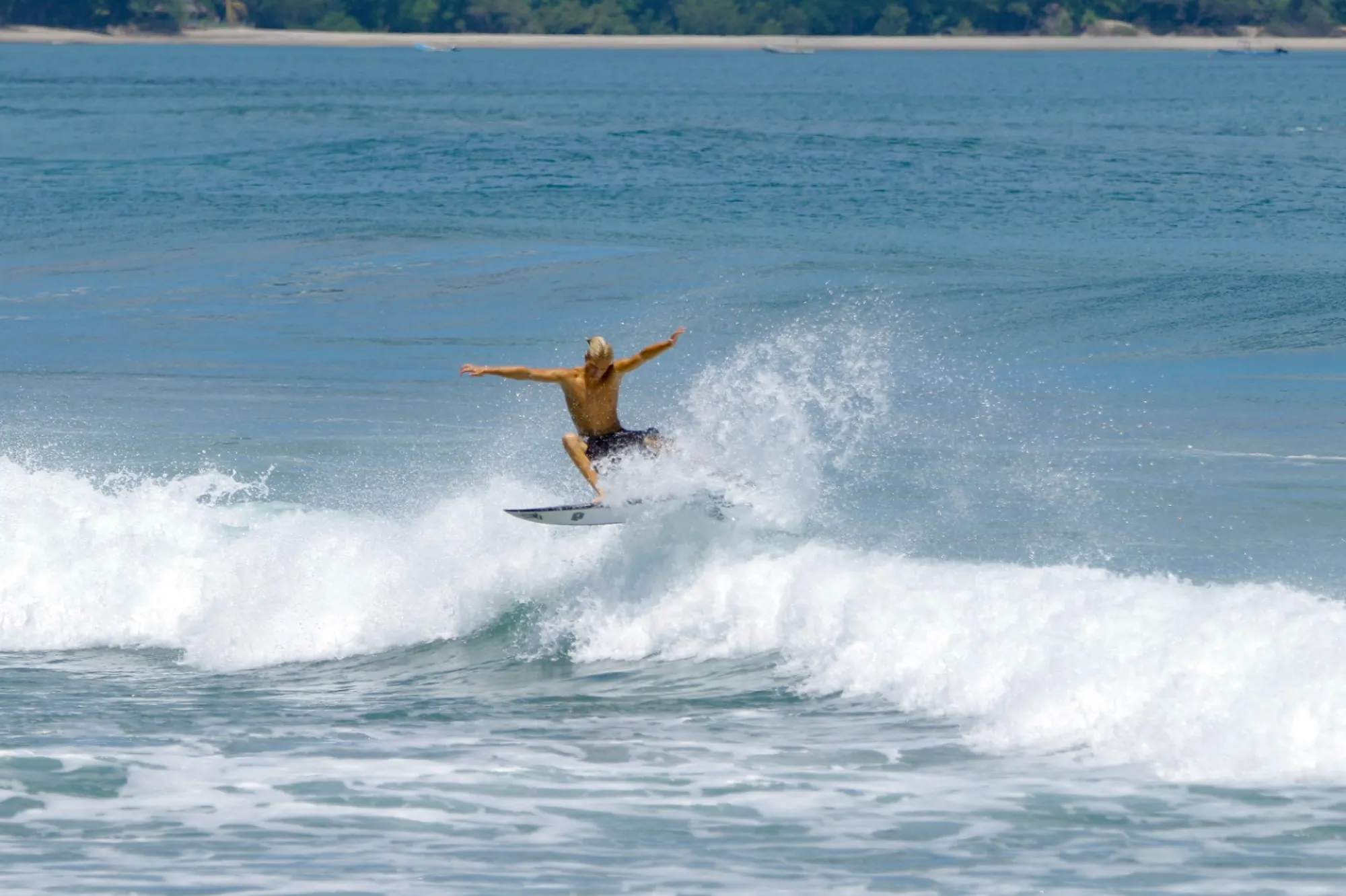 Surfer performs a stylish carve on a small wave.